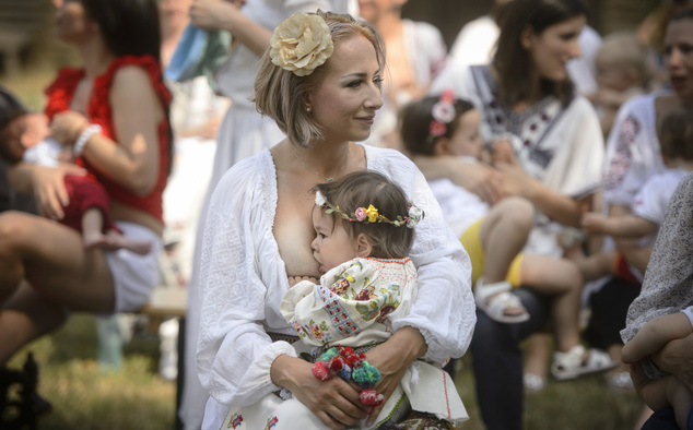 A woman breastfeeds her eighteen-month-old daughter Anastasia at an event promoting the freedom of mothers to breastfeed in public, during World Breastfeeding Week at the Village Museum in Bucharest, Romania, Saturday, Aug. 6, 2016. (AP Photo/Andreea Alexandru)
